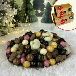 Mélange de Noël contenant des noisettes-amandes, raisins, mogettes (coeur nougatine enrobé de chocolat) et de billes d ecéréales enrobés de chocolat noir, lait et blanc