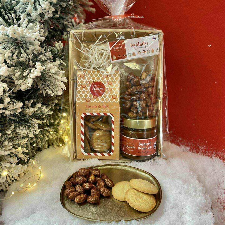 Bourriche de Noël avec sachet de cacahuètes caramélisées, un coffret cartonné de biscuits de Noël, un pot de caramel au beurre salé