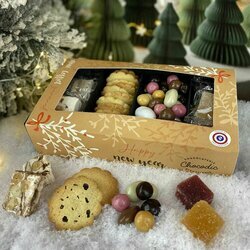 Coffret gourmand pour Noël avec nougats, biscuits, noisettes, amandes et raisins enrobés de chocolats et pâtes de fruits