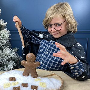 Enfant qui tient une baguette magique en chocolat de Noël