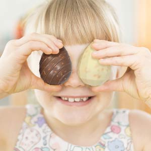 Enfant qui tient deux oeufs en chocolats de Pâques